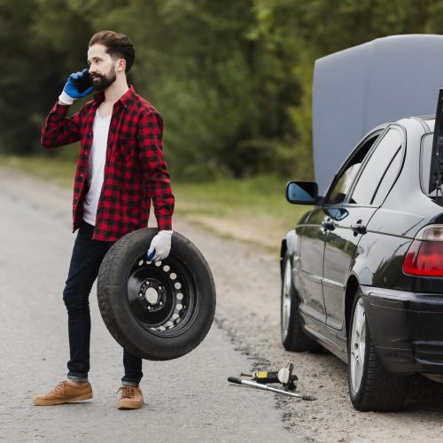 man-holding-tire-talking-phone